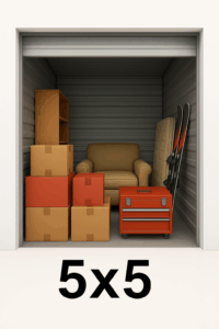 View through an open door of a 5ft by 5ft self-storage unit, showing a sofa chair with multiple boxes stacked beside and in front of it. 